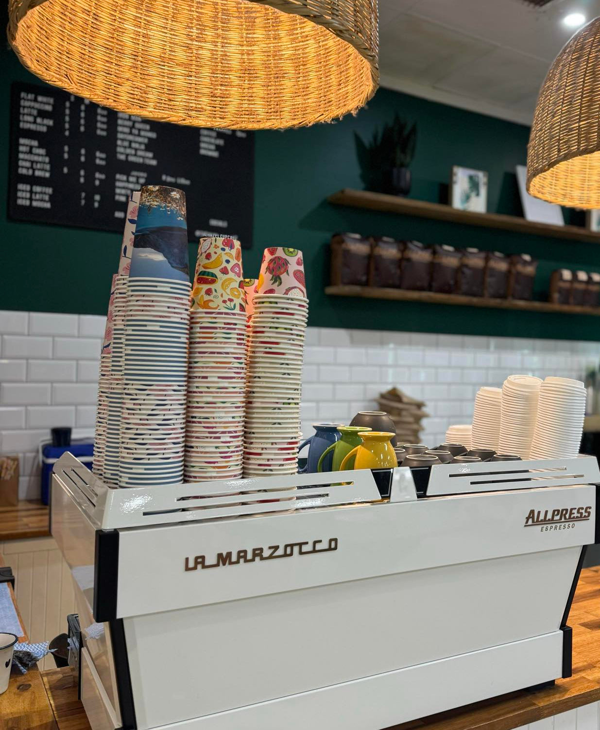 printed pretty takeaway coffee cups sitting on coffee machine